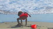 girl-in-red with-red-bucket-on-beach